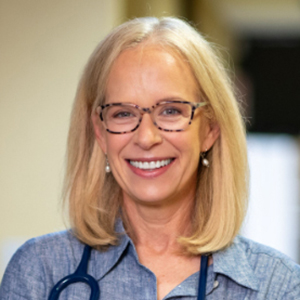 Portrait of Dr. Kelly Morrison with a stethoscope around her neck in a doctor's office.