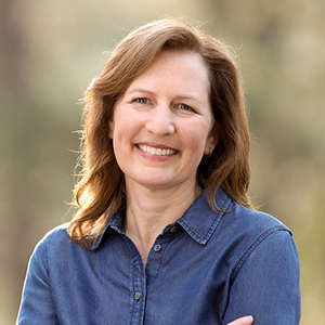 Portrait of Dr. Kim Schrier wearing a collared shirt outside.