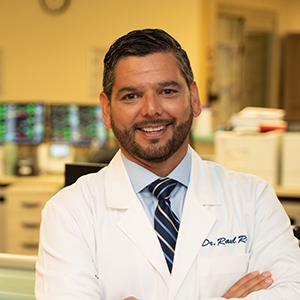 Portrait of Dr. Raul Ruiz wearing a white doctor's coat.